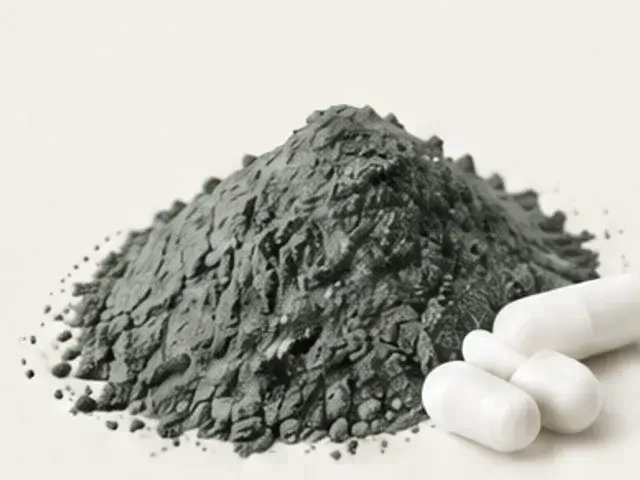 Dark iron bisglycinate powder beside two capsules